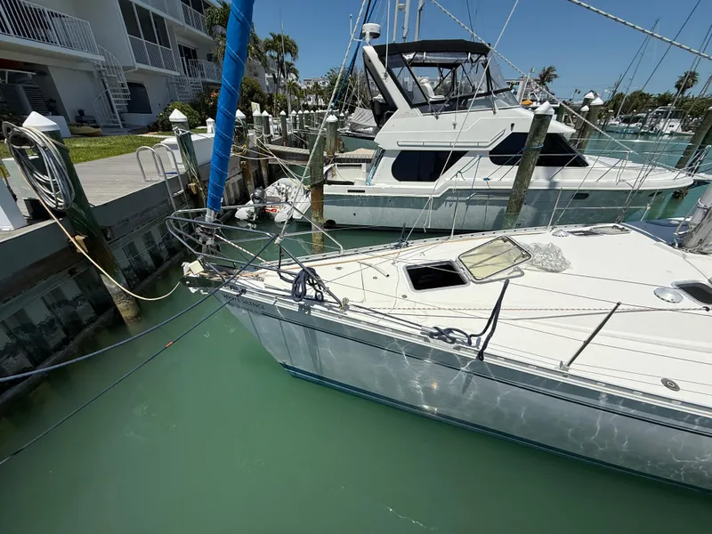 Slide: The Image of Jeanneau Sun Odyssey 42.2 sailboat docked in marina, 1998 model, calm waters. - 16