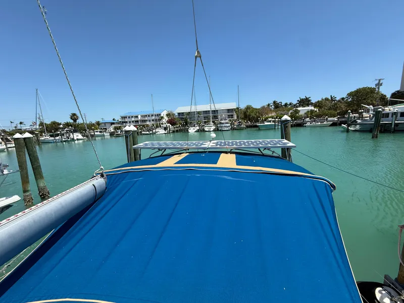 Slide: The Image of Sailboat Jeanneau Sun Odyssey 42.2, 1998, docked in a sunny marina with blue canopy. - 19