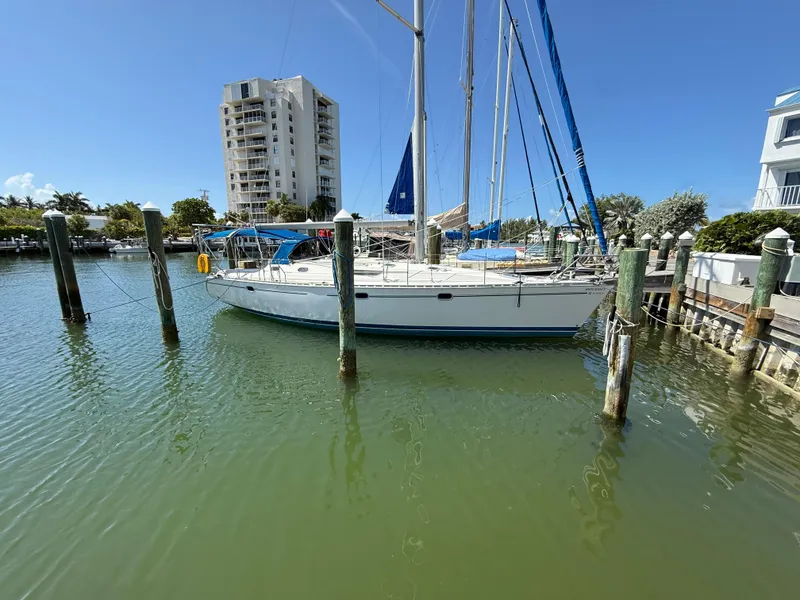 Slide: The Image of 1999 Jeanneau Sun Odyssey 42.2 sailboat docked in a marina, clear blue sky. - 2