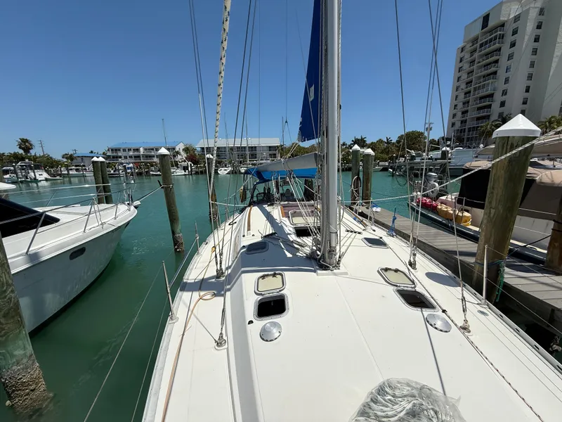 Slide: The Image of 1998 Jeanneau Sun Odyssey 42.2 sailboat docked in a marina under clear blue skies. - 21