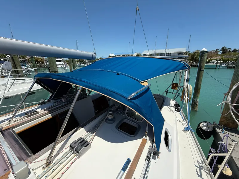 Slide: The Image of 1998 Jeanneau Sun Odyssey 42.2 sailboat with blue canopy docked in marina. - 29
