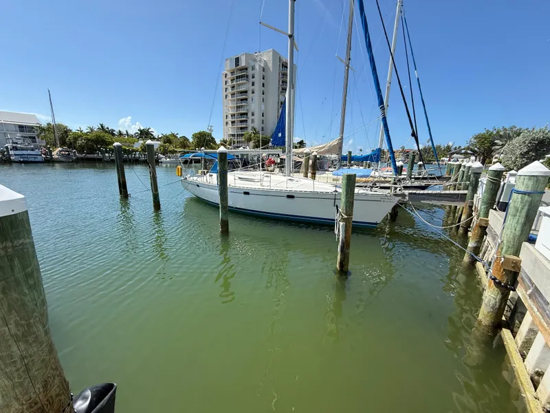 Slide: The Image of 1999 Jeanneau Sun Odyssey 42.2 sailboat docked in a marina with clear blue sky. - 3