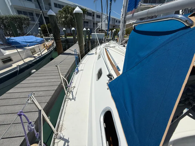 Slide: The Image of 1998 Jeanneau Sun Odyssey 42.2 sailboat docked at marina, featuring blue canopy. - 31