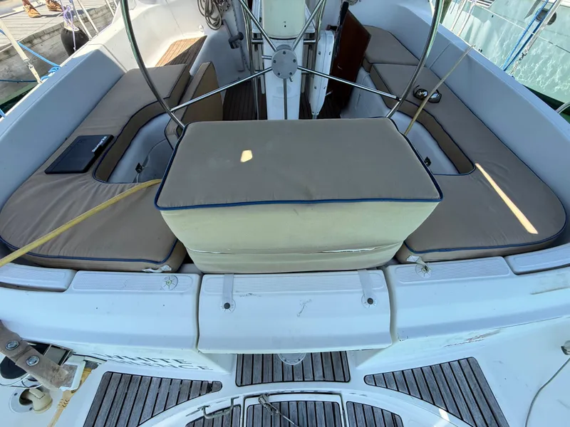 Slide: The Image of Cockpit of 1998 Jeanneau Sun Odyssey 42.2 sailboat with cushioned seating and steering wheel. - 35