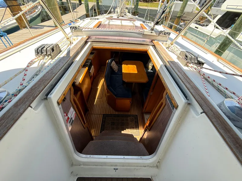 Slide: The Image of 1998 Jeanneau Sun Odyssey 42.2 sailboat interior with wooden furnishings and seating area. - 44
