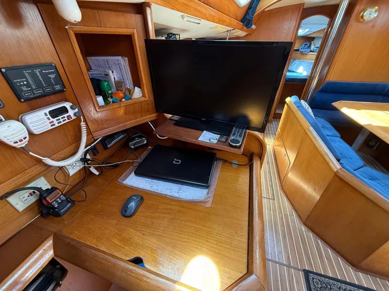 Slide: The Image of Navigation station inside 1998 Jeanneau Sun Odyssey 42.2 sailboat with electronics and wooden interior. - 51