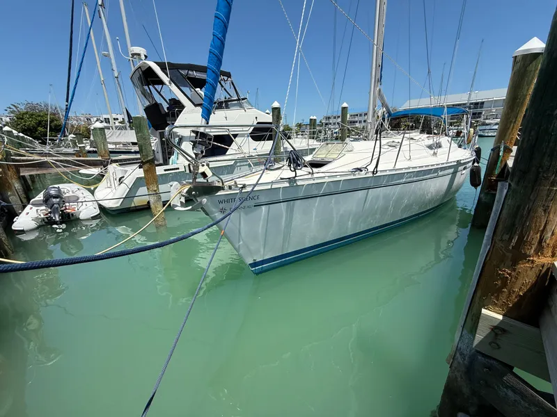 Slide: The Image of 1998 Jeanneau Sun Odyssey 42.2 sailboat docked in a marina with clear blue water. - 6