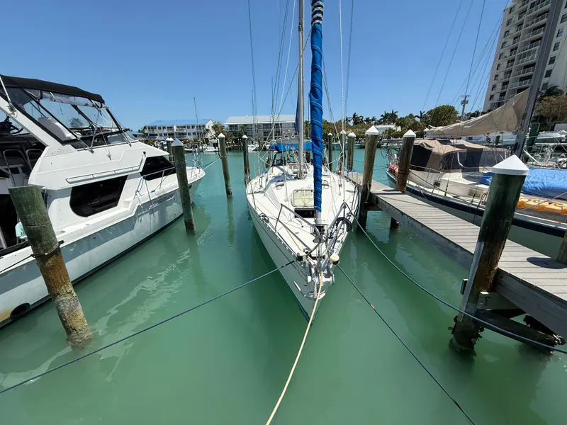 Slide: The Image of Sailboat Jeanneau Sun Odyssey 42.2, 1998 model, docked in a marina with clear blue water. - 8