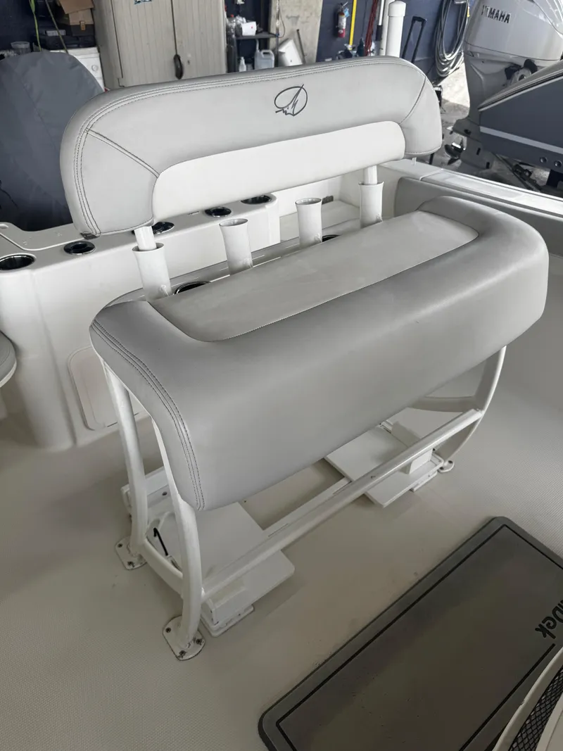 Slide: The Image of 2015 Sailfish 220 CC boat seat with rod holders and cushioned backrest. - 12