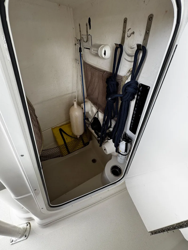 Slide: The Image of 2015 Sailfish 220 CC storage compartment with ropes and equipment. - 15