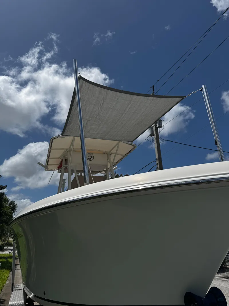 Slide: The Image of 2015 Sailfish 220 CC boat with canopy under a clear blue sky. - 2