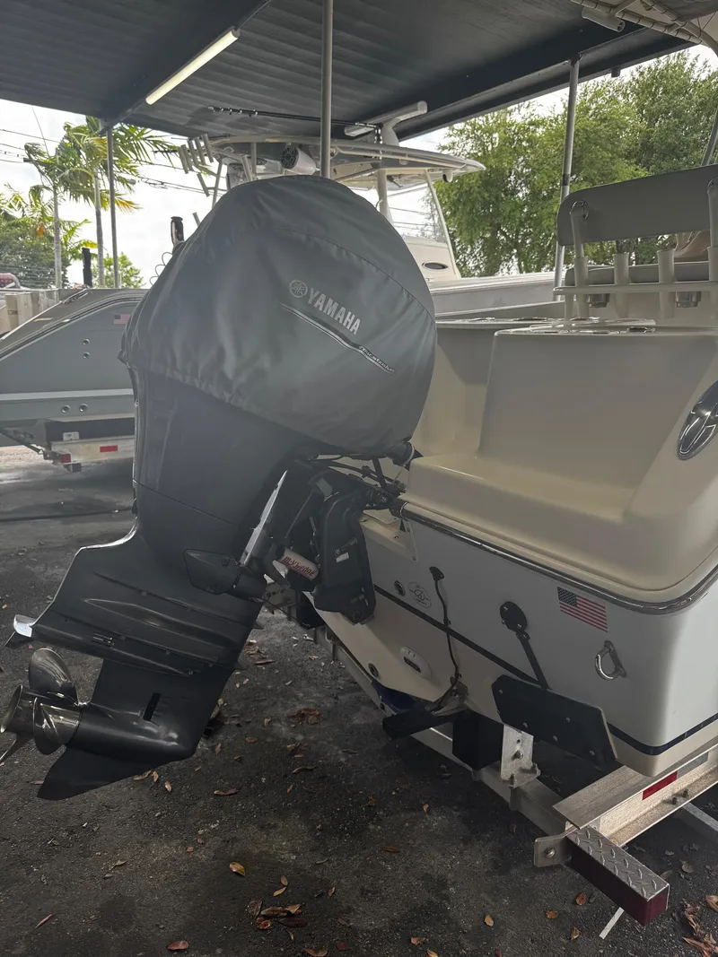 Slide: The Image of 2015 Sailfish 220 CC boat with Yamaha outboard motor, parked under a shelter. - 21