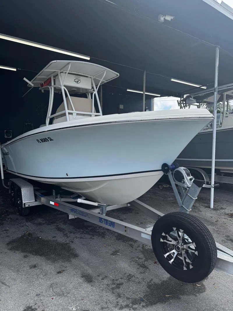 Slide: The Image of 2015 Sailfish 220 CC boat on trailer, parked under a shelter. - 23