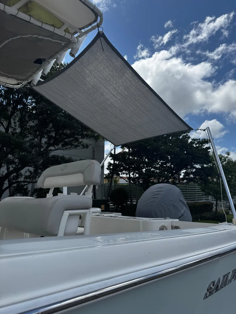 Slide: The Image of 2015 Sailfish 220 CC boat with sunshade, under a partly cloudy sky. - 6