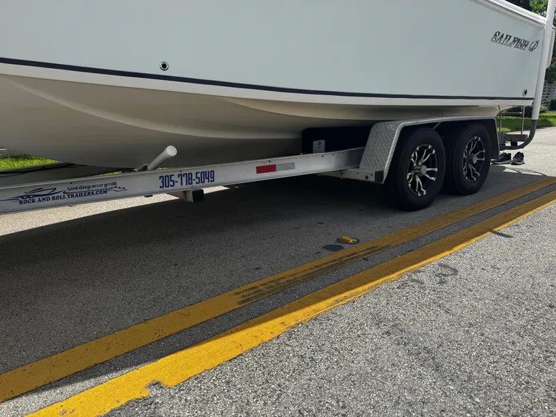 Slide: The Image of 2015 Sailfish 220 CC boat on trailer, parked on a road. - 7