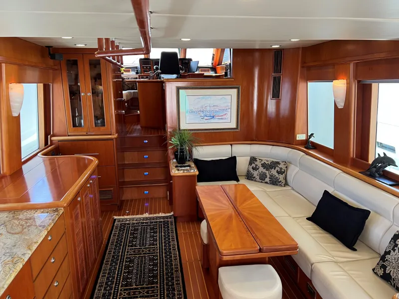 Slide: The Image of Luxurious yacht interior with wooden finishes, white seating, and elegant decor, Symbol PHMY 2007 model. - 2