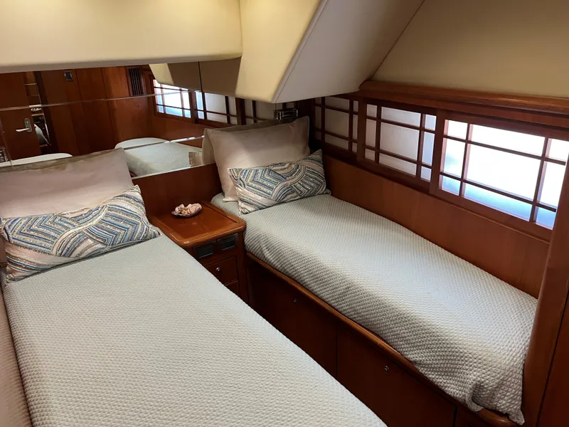 Slide: The Image of Twin beds in a 2007 Symbol PHMY yacht cabin with wooden accents and soft lighting. - 6