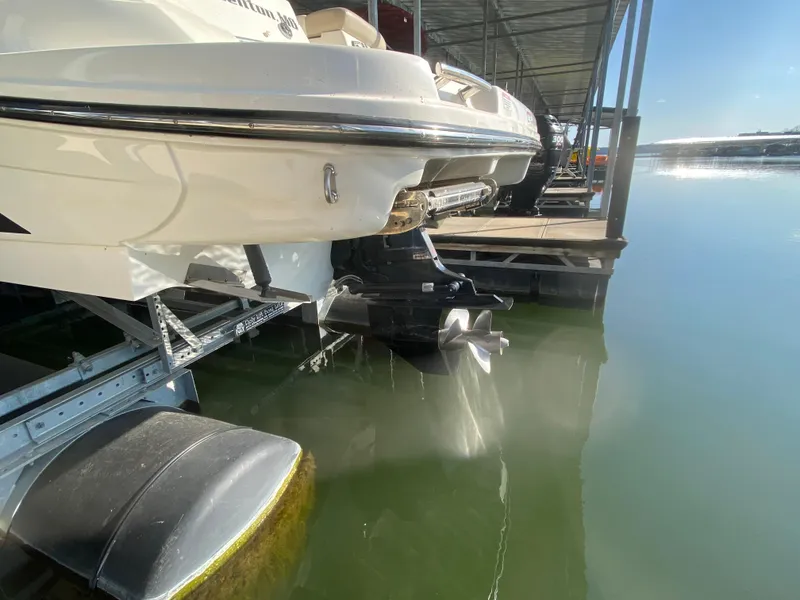 Slide: The Image of 2012 Sea Ray 270 SLX boat docked, rear view showing propeller and water reflection. - 11