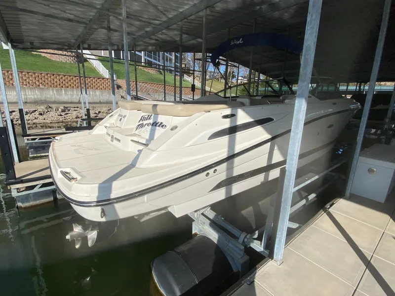 Slide: The Image of 2012 Sea Ray 270 SLX boat docked in a covered marina. - 12