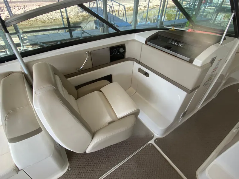 Slide: The Image of Interior of 2012 Sea Ray 270 SLX boat with beige seating and helm controls. - 26