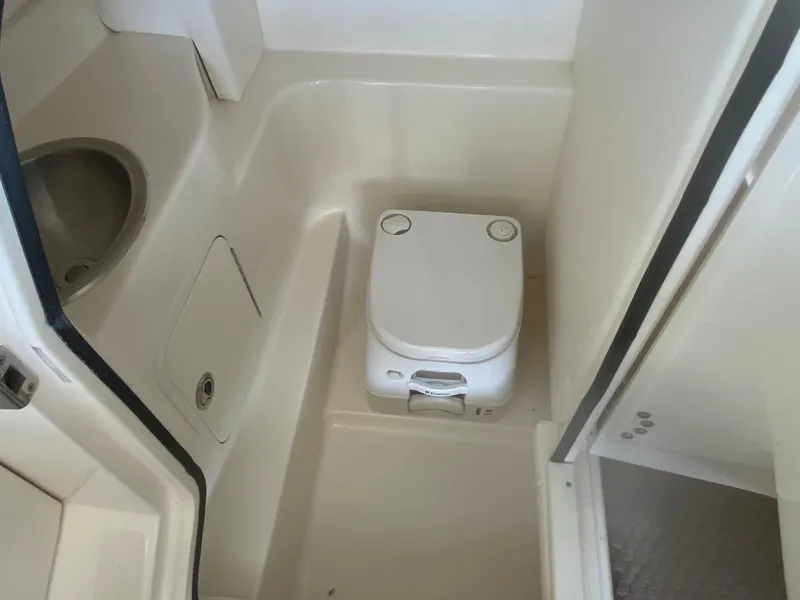 Slide: The Image of 2012 Sea Ray 270 SLX boat bathroom with compact toilet and sink. - 28