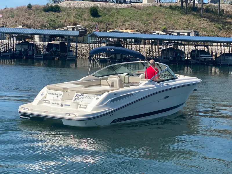 Slide: The Image of 2012 Sea Ray 270 SLX boat cruising on a lake near a marina. - 6