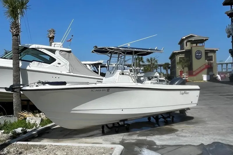 Slide: The Image of 2007 Edgewater 228 boat on display at a marina under clear blue skies. - 1