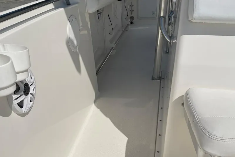 Slide: The Image of Interior view of a 2007 Edgewater 228 boat, featuring white seating and cup holders. - 11
