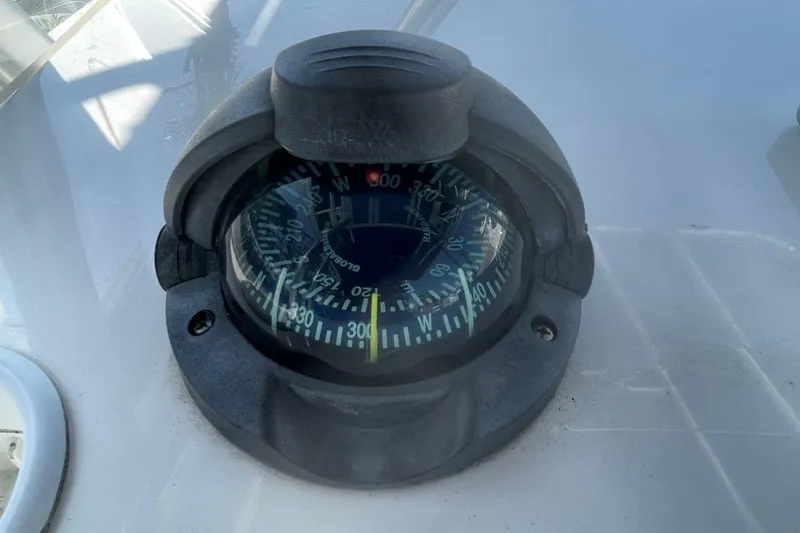 Slide: The Image of Compass on 2007 Edgewater 228 boat dashboard, showing navigational directions. - 18