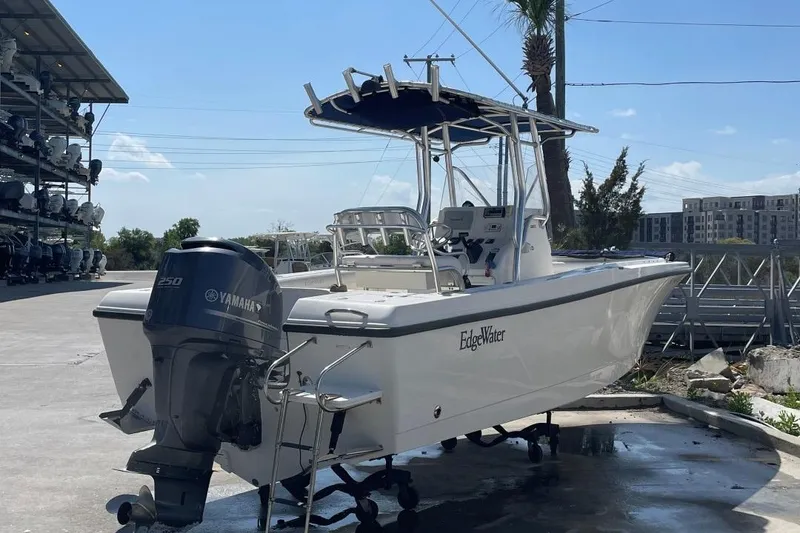 Slide: The Image of 2007 Edgewater 228 boat with Yamaha engine, docked outdoors under clear sky. - 2