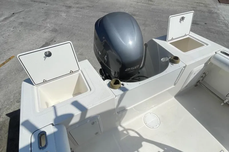 Slide: The Image of 2007 Edgewater 228 boat with open storage compartments and outboard motor. - 24