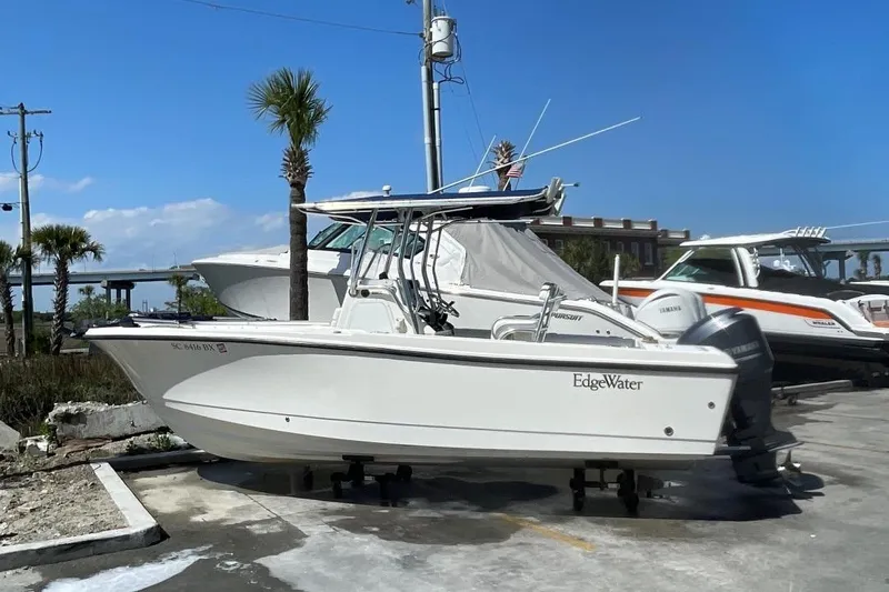 Slide: The Image of 2007 Edgewater 228 boat on trailer, parked outdoors under clear blue sky. - 3