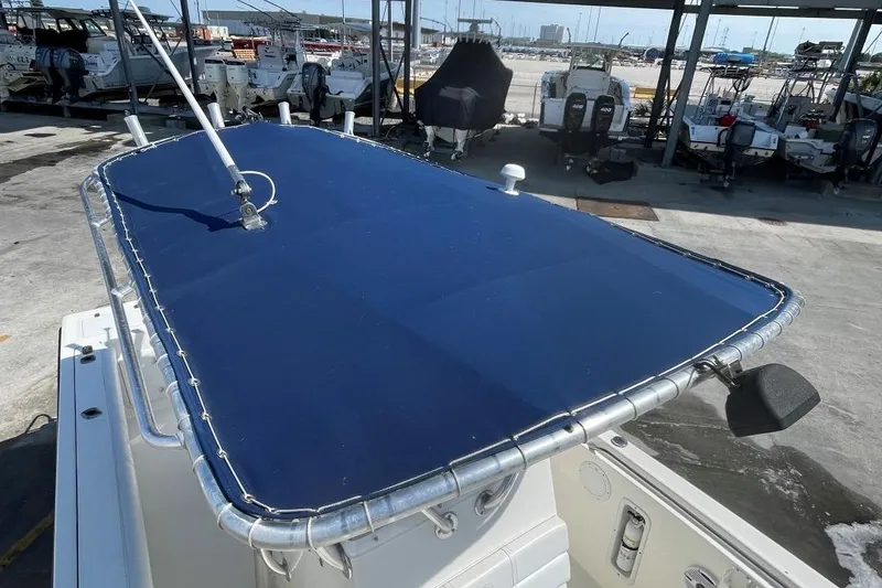 Slide: The Image of 2007 Edgewater 228 boat with blue canvas top in a marina setting. - 5