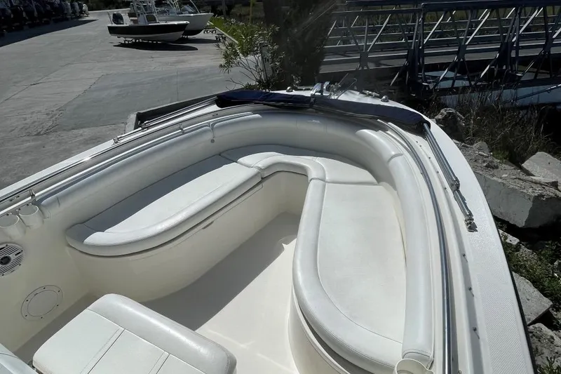 Slide: The Image of 2007 Edgewater 228 boat with white seating, docked near a marina. - 6