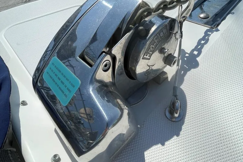 Slide: The Image of Chrome boat winch on 2007 Edgewater 228, with chain and textured deck surface. - 8