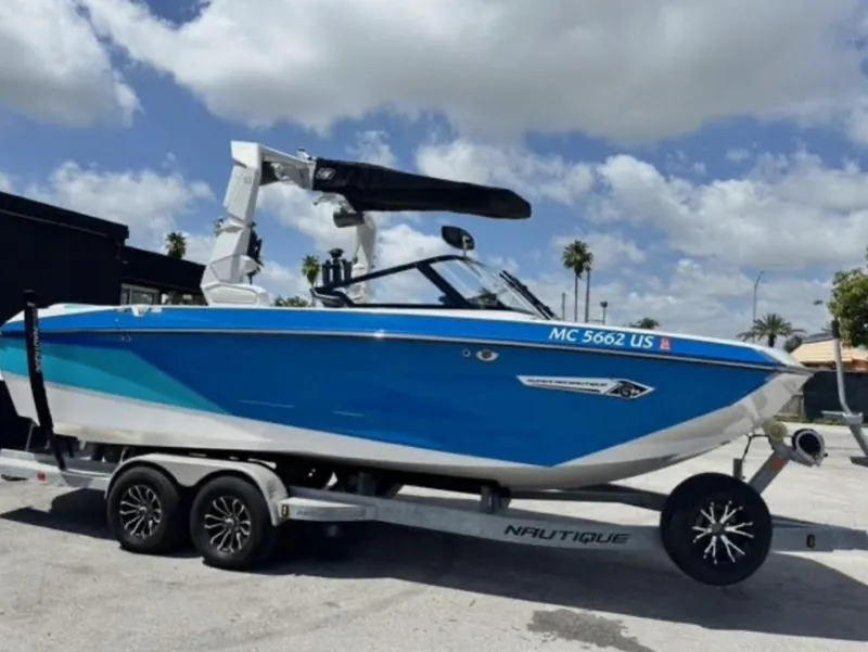 Slide: The Image of 2022 Nautique Super Air Nautique G23 boat on trailer under blue sky. - 1