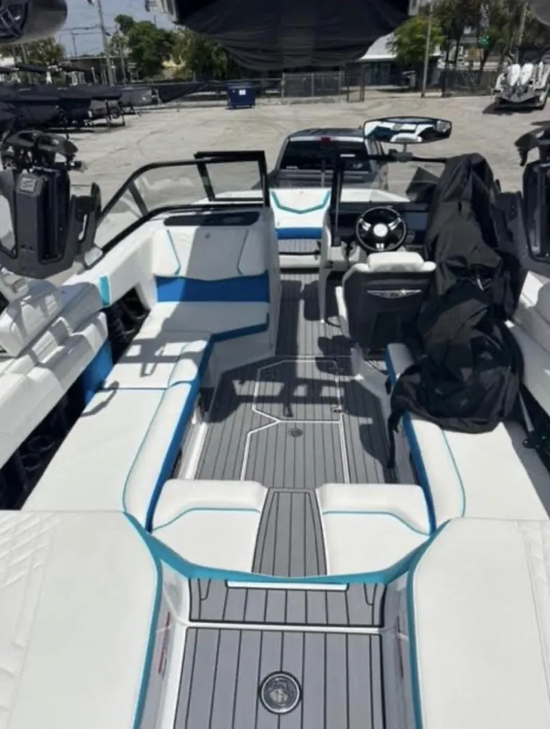 Slide: The Image of 2022 Nautique Super Air Nautique G23 boat interior with white and blue seating. - 2