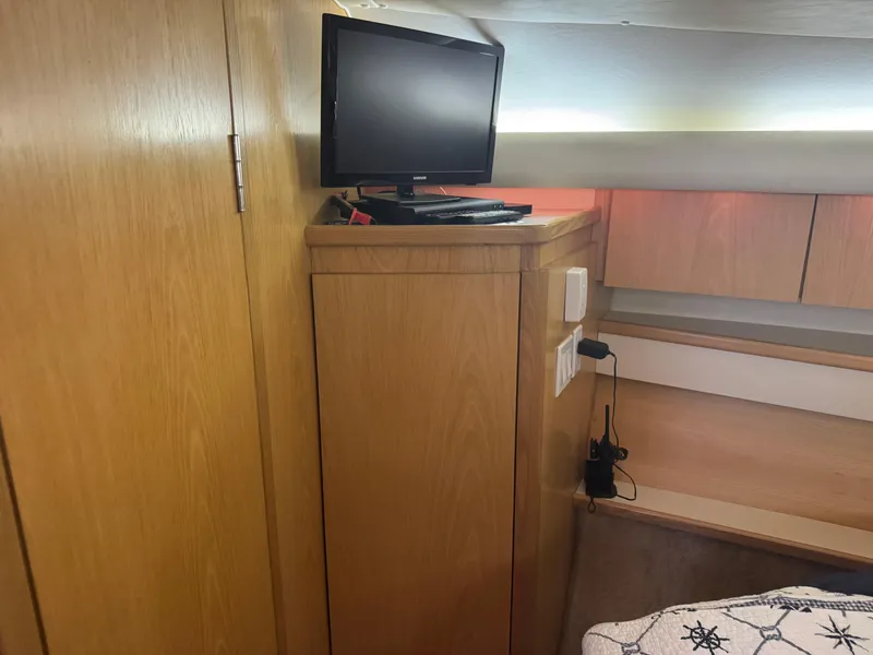 Slide: The Image of Interior of 2000 Tiara Yachts 4000 Express with TV and wooden cabinetry. - 16