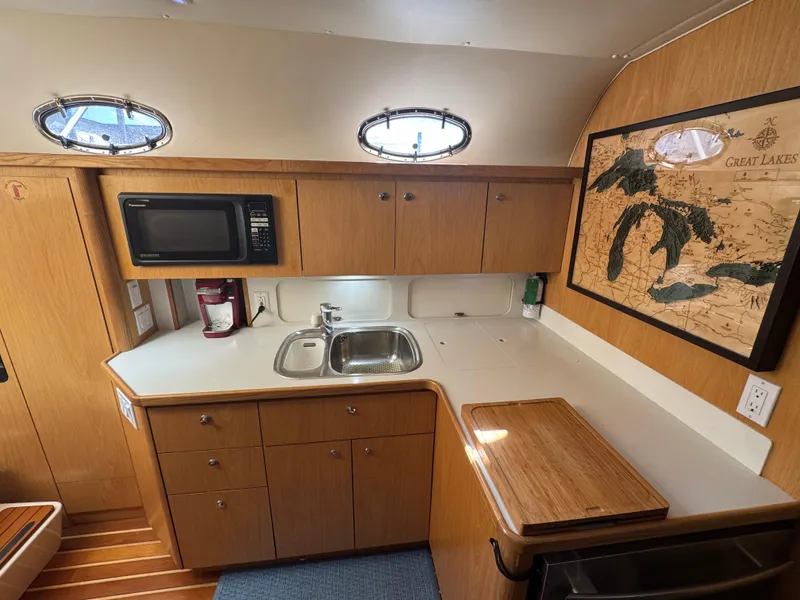 Slide: The Image of Compact kitchen in a 2000 Tiara Yachts 4000 Express, featuring wood cabinetry and a microwave. - 7