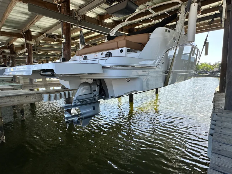 Slide: The Image of 2023 Four Winns HD8 boat docked in a covered marina, rear view. - 1