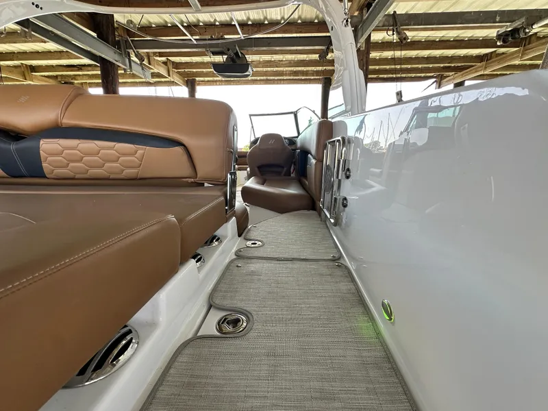 Slide: The Image of 2023 Four Winns HD8 boat interior with brown leather seating and modern design. - 17