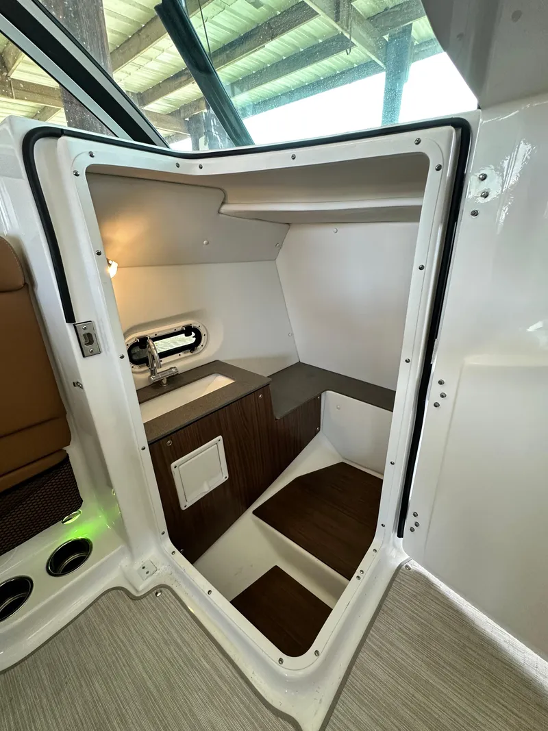 Slide: The Image of 2023 Four Winns HD8 boat interior cabin with sink and wooden accents. - 26