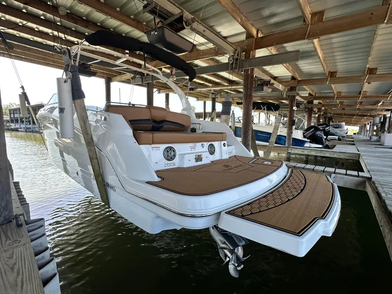 Slide: The Image of 2023 Four Winns HD8 boat docked under a covered marina. - 3
