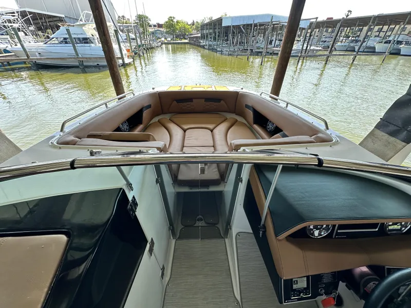 Slide: The Image of 2023 Four Winns HD8 boat interior with tan seating, docked at marina. - 36