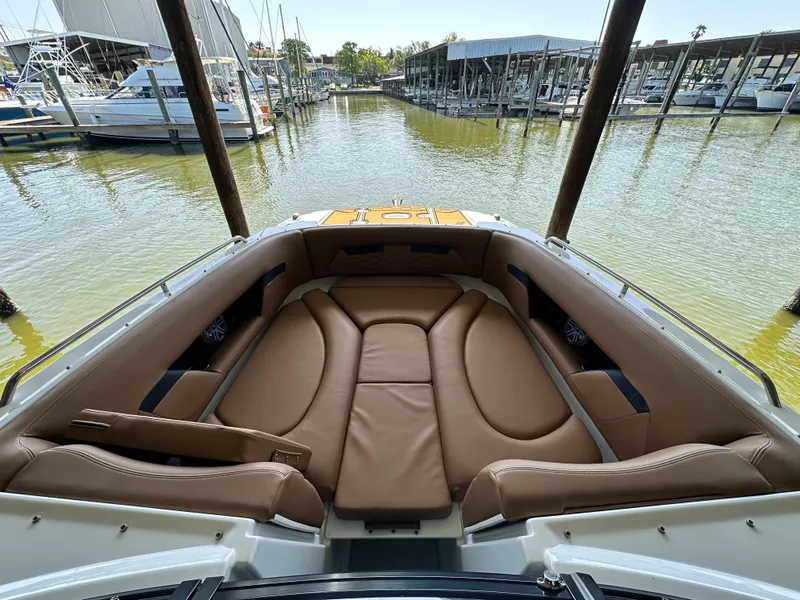 Slide: The Image of 2023 Four Winns HD8 boat with spacious, luxurious seating in a marina setting. - 37