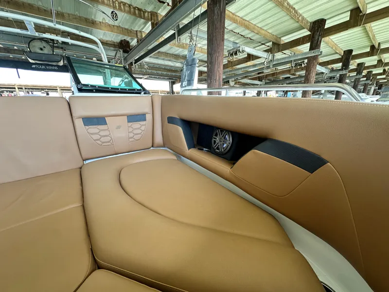 Slide: The Image of 2023 Four Winns HD8 boat interior with tan seating and speaker detail. - 40
