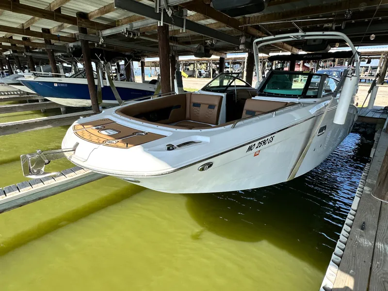 Slide: The Image of 2023 Four Winns HD8 boat docked in a marina under a covered structure. - 5