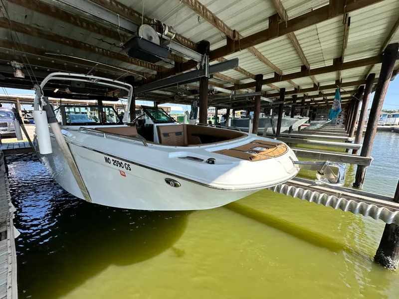 Slide: The Image of 2023 Four Winns HD8 boat docked in a covered marina. - 7