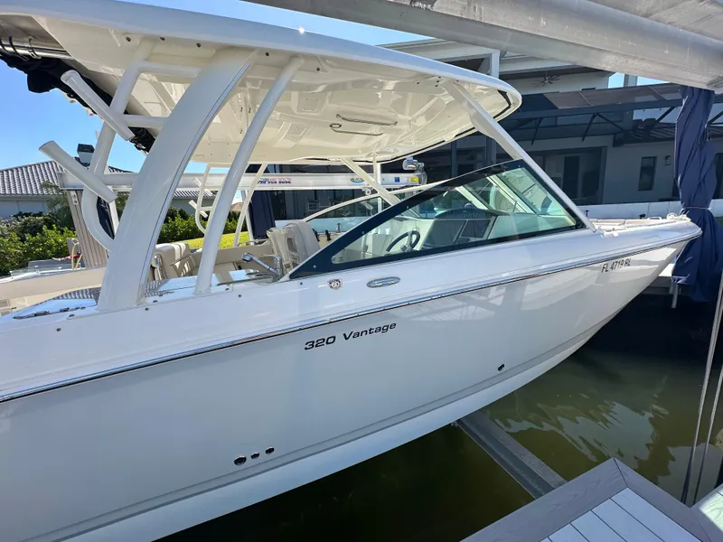 Slide: The Image of 2018 Boston Whaler 320 Vantage boat docked, showcasing sleek design and modern features. - 10
