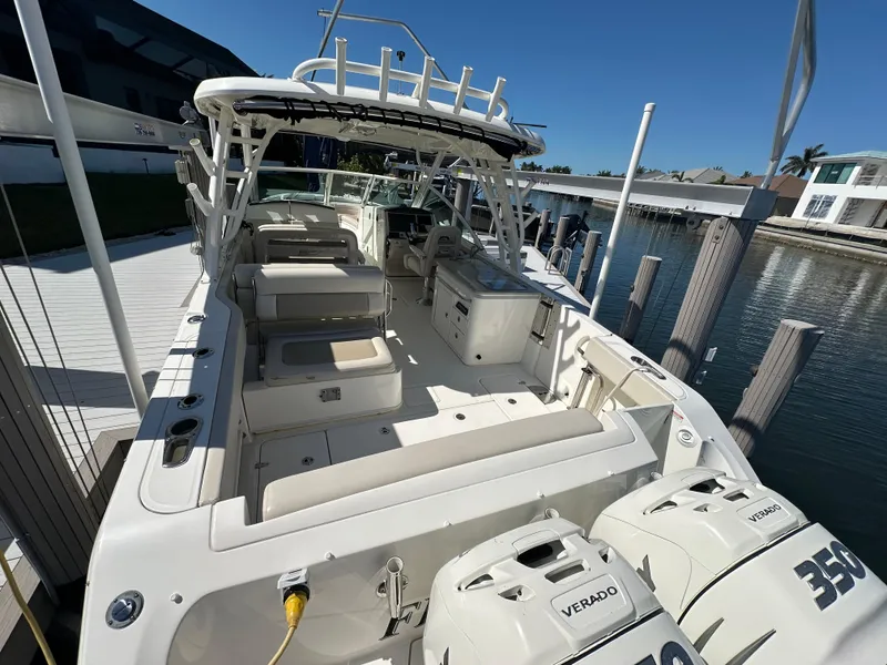 Slide: The Image of 2018 Boston Whaler 320 Vantage boat interior with seating, dockside view, and sunny weather. - 14